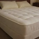 Colchón hinchable puesto en una cama con sus almohadas correspondientes